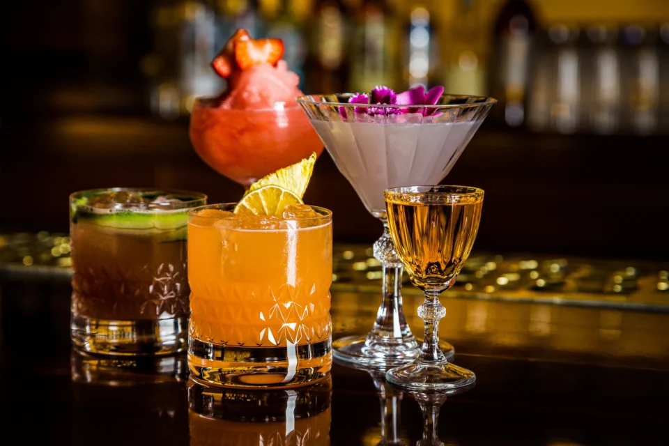 Conjunto de bebidas de Doble B: distintas formas, colores y ambiente de barra.